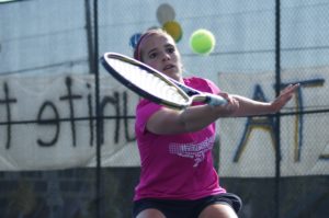 Girl hits tennis ball