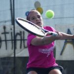 Girl hits tennis ball